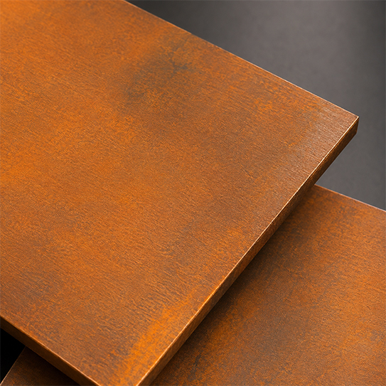 Plaque d’acier Corten en phase active avec teinte orange indiquant le développement de la patine.
