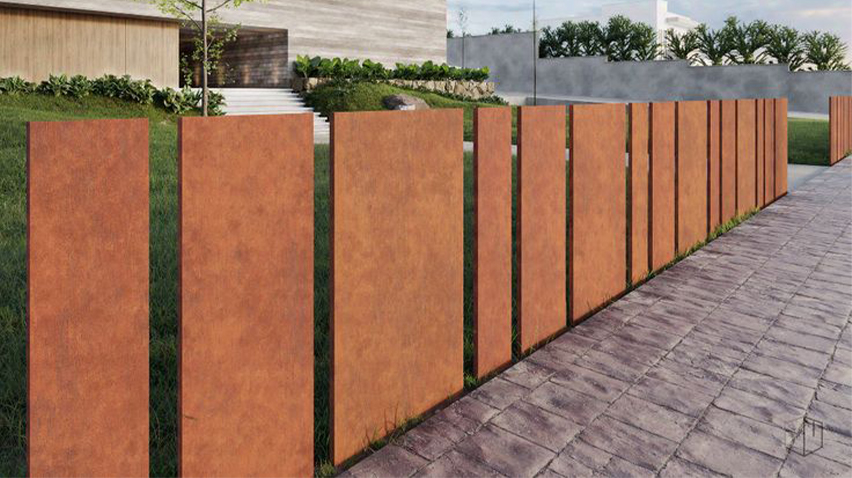 Clôture extérieure composée de panneaux verticaux en acier Corten disposés le long d’une allée paysagère.