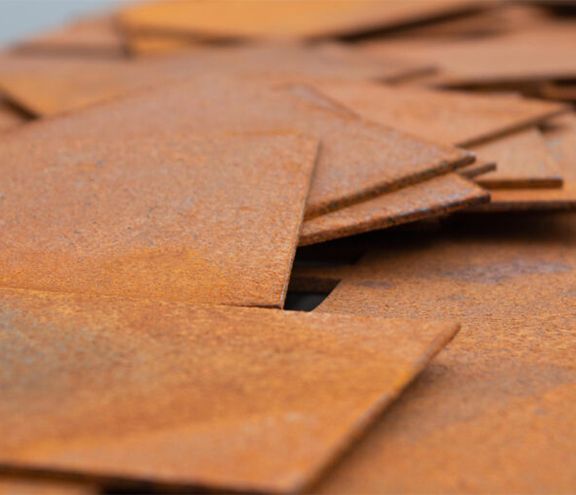 Échantillons de tôles en acier Corten présentant une patine brun-orangée pour illustrer un guide technique du matériau.