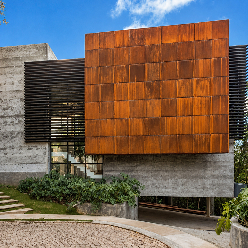 Villa contemporaine agrandie par plusieurs volumes géométriques habillés de panneaux en acier Corten autour des fenêtres.