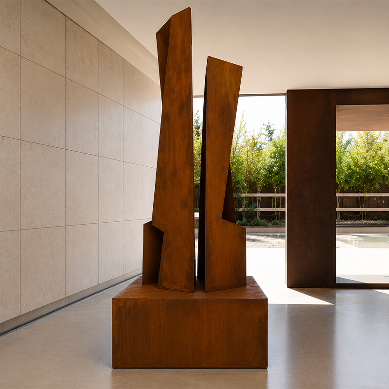 Sculpture abstraite verticale composée de deux volumes élancés en acier Corten sur un socle rectangulaire dans un intérieur contemporain.